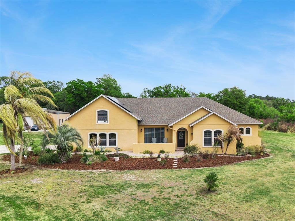 7139 Groveland Farms Road Groveland, FL 34736 - Photo 35 of 36 a front view of a house with a garden and yard