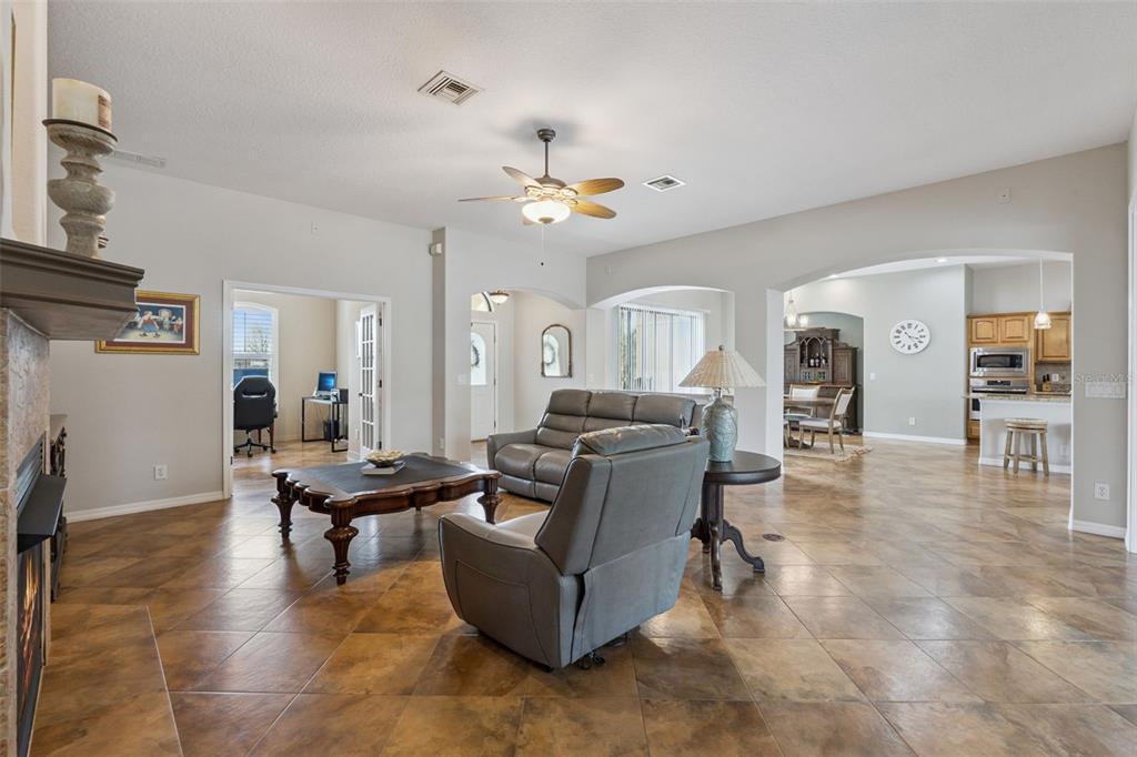 7139 Groveland Farms Road Groveland, FL 34736 - Photo 5 of 36 a living room with couches and kitchen view with wooden floor