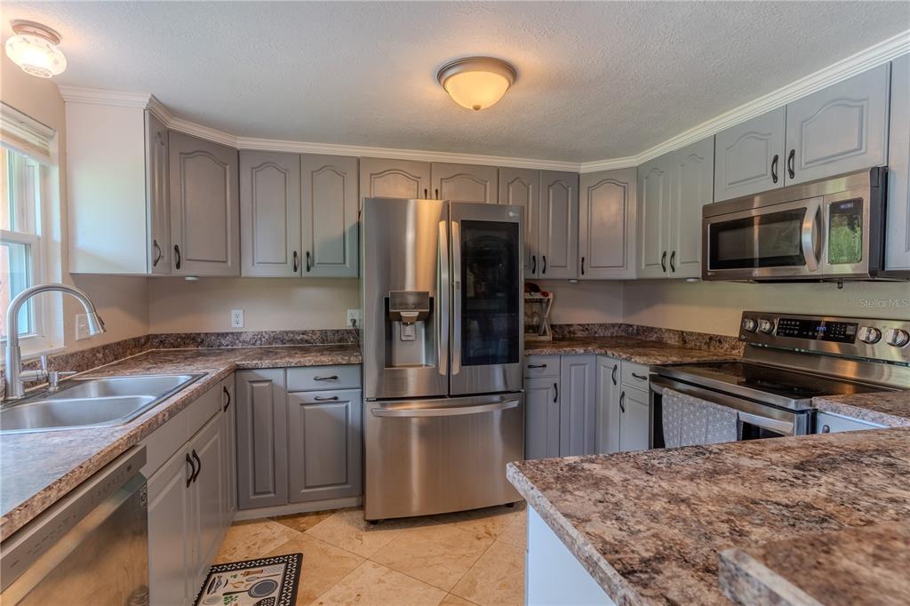 147 Hayes Street Lake Wales, FL 33859 - Photo 5 of 31 a kitchen with granite countertop a refrigerator stove and microwave