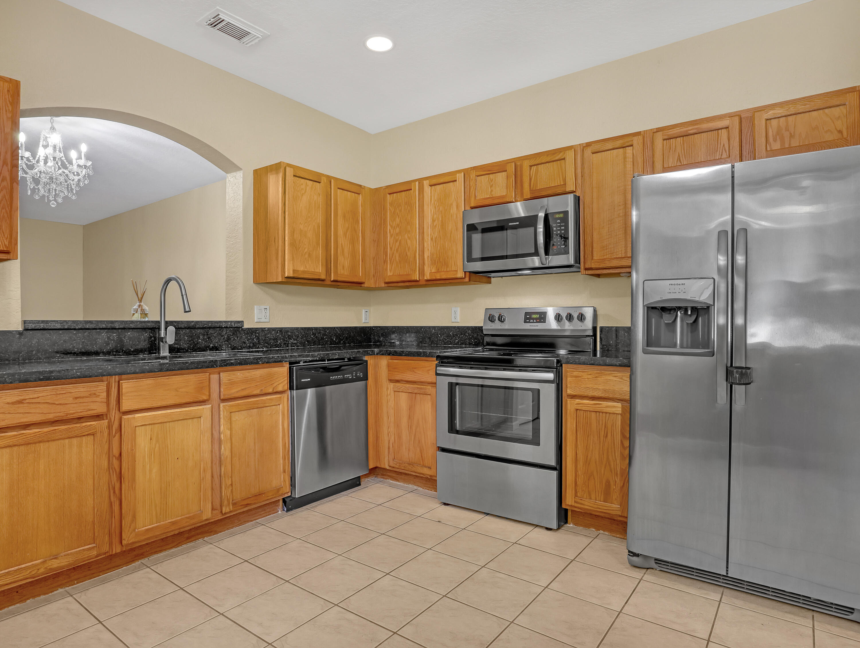 a kitchen with stainless steel appliances granite countertop a refrigerator and a stove top oven