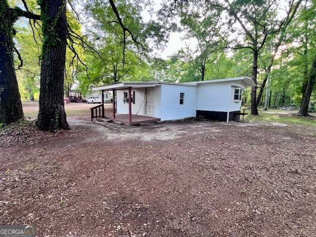 3195 Henderson Grove Road Sandersville, GA 31082 - Photo 24 of 50 a view of a house with large trees and wooden fence