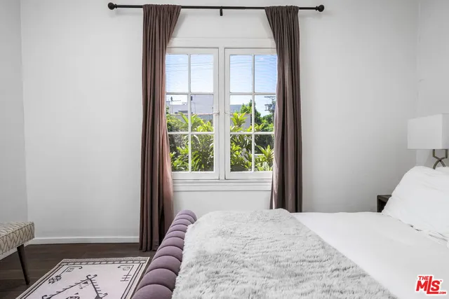 a bed sitting in a bedroom next to a window