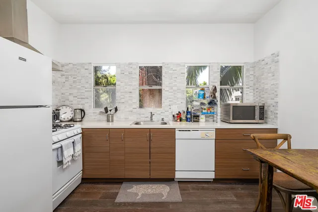 a kitchen with stainless steel appliances white cabinets and wooden floor