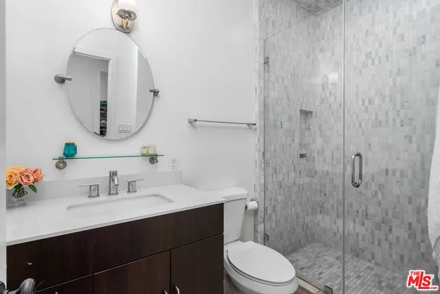 a bathroom with a sink a toilet and shower