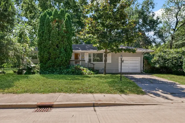 a front view of a house with a yard and a garage