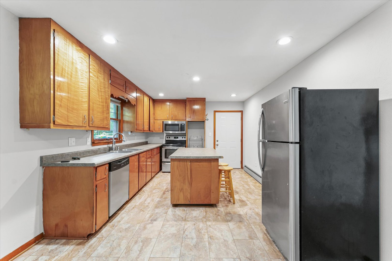 1507 West Columbia Avenue Champaign, IL 61821 - Photo 11 of 28 a kitchen with stainless steel appliances granite countertop a refrigerator a stove a sink and a microwave