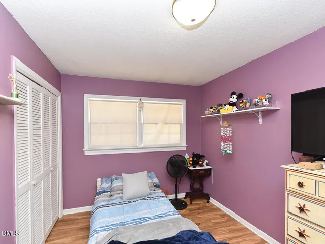 a bedroom with a bed and wooden floor