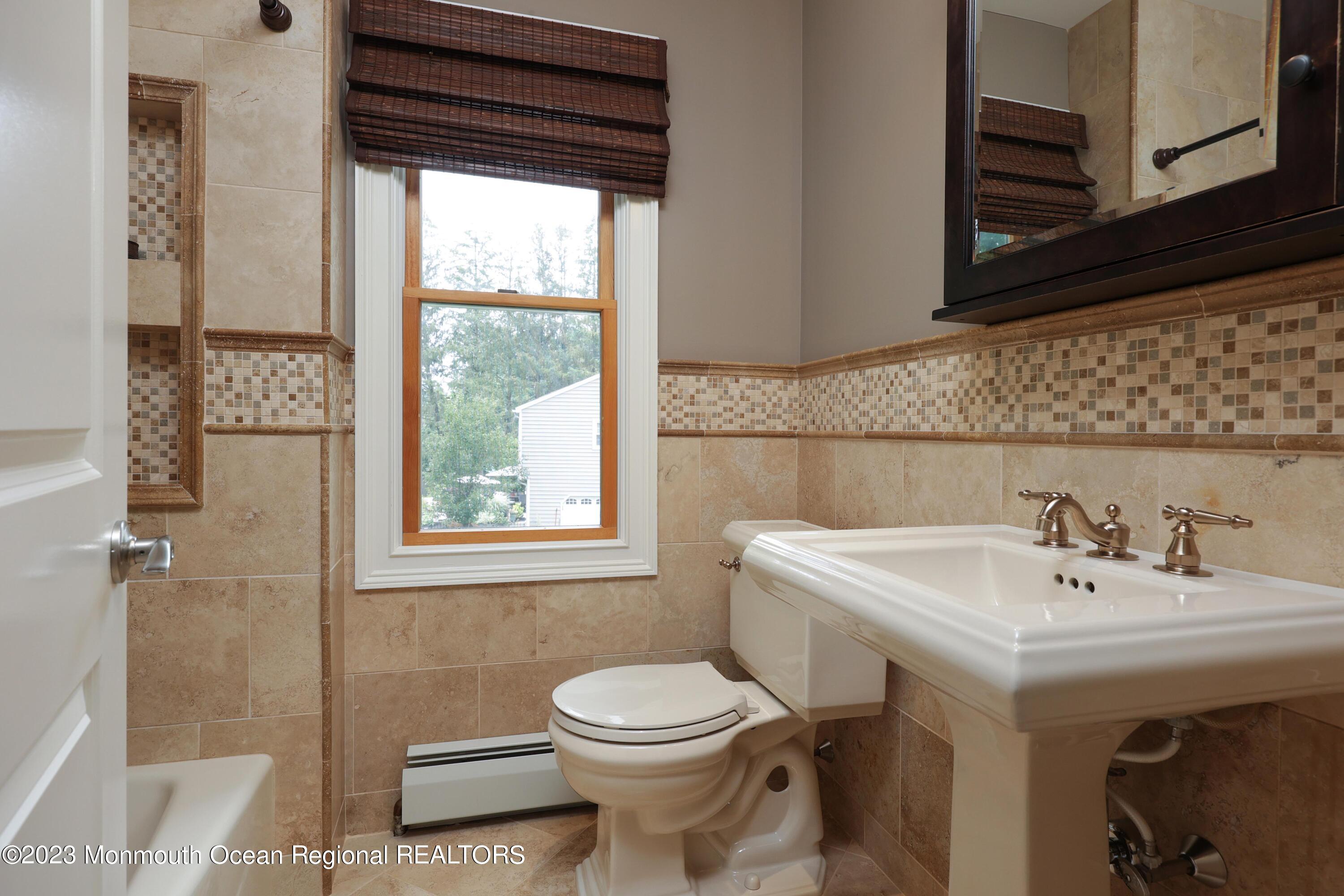 113 Ballantine Road Middletown, NJ 07748 - Photo 13 of 15 a bathroom with a sink a toilet and shower