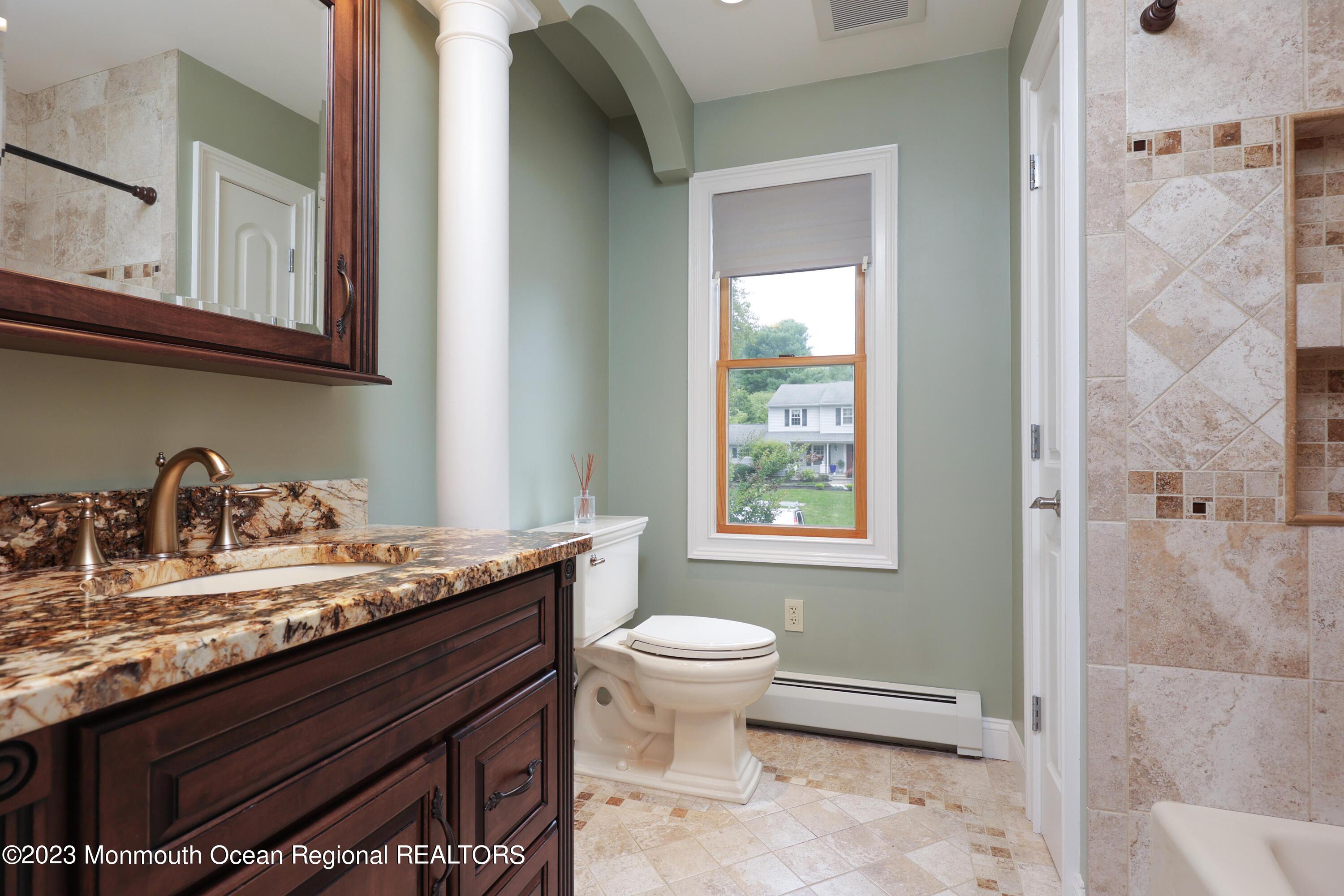 113 Ballantine Road Middletown, NJ 07748 - Photo 14 of 15 a bathroom with a granite countertop sink a toilet and a mirror