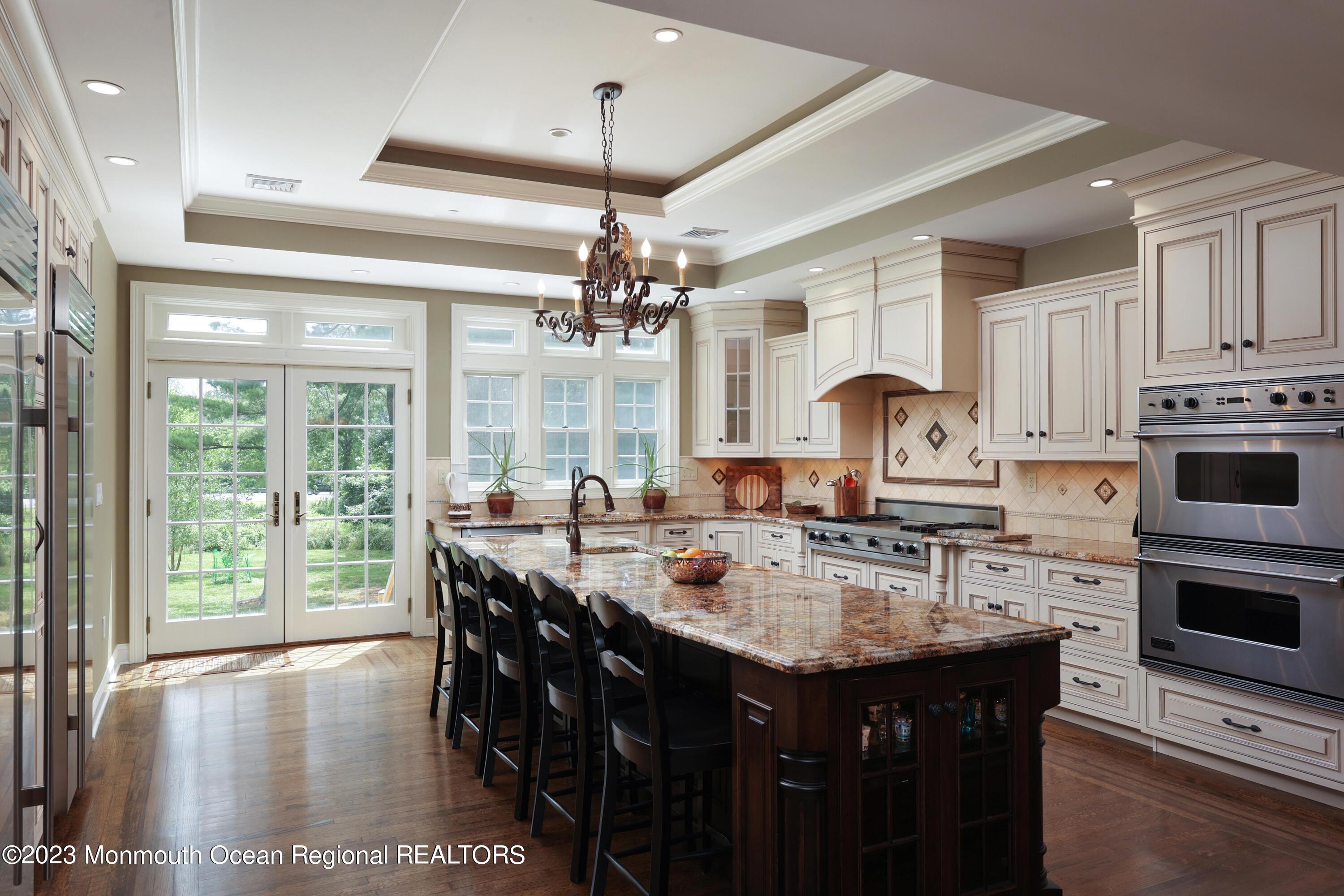 113 Ballantine Road Middletown, NJ 07748 - Photo 4 of 15 a kitchen with kitchen island granite countertop a sink stove and cabinets
