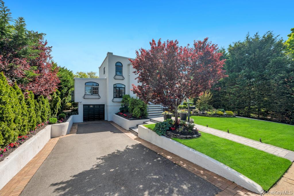 357 Wynsum Avenue Merrick, NY 11566 - Photo 2 of 40 a front view of a house with a yard and a garden
