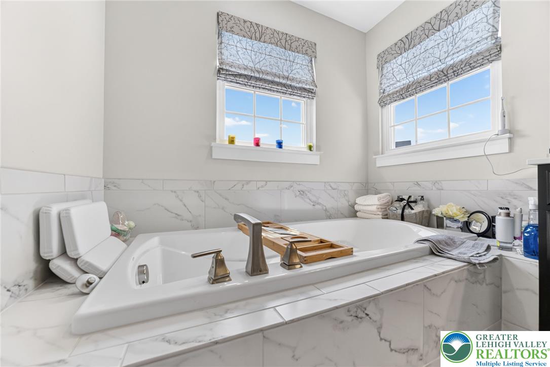 3952 Orth Street Bethlehem, PA 18020 - Photo 26 of 60 Marble tile surrounds this luxurious soaking tub, offering a tranquil retreat.