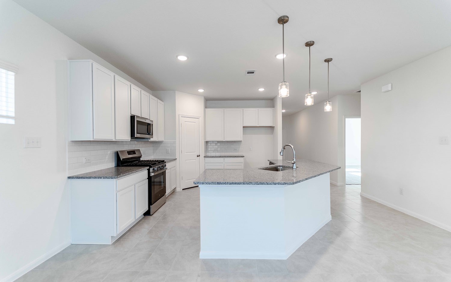 426 Monarch Trail Huntsville, TX 77340 - Photo 5 of 16 a large white kitchen with kitchen island a sink a stove a oven a dining table and chairs