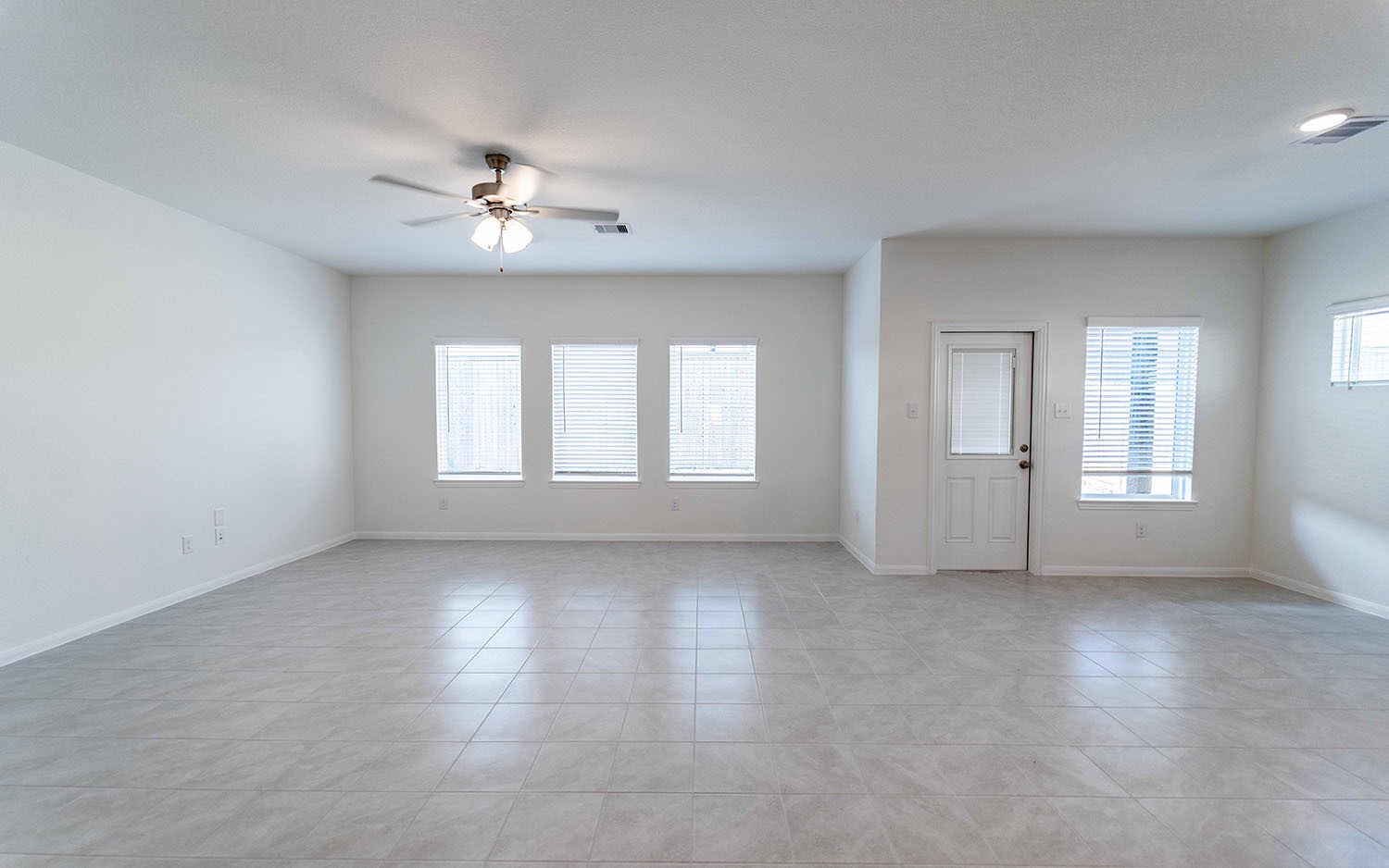 426 Monarch Trail Huntsville, TX 77340 - Photo 9 of 16 an empty room with chandelier fan and windows