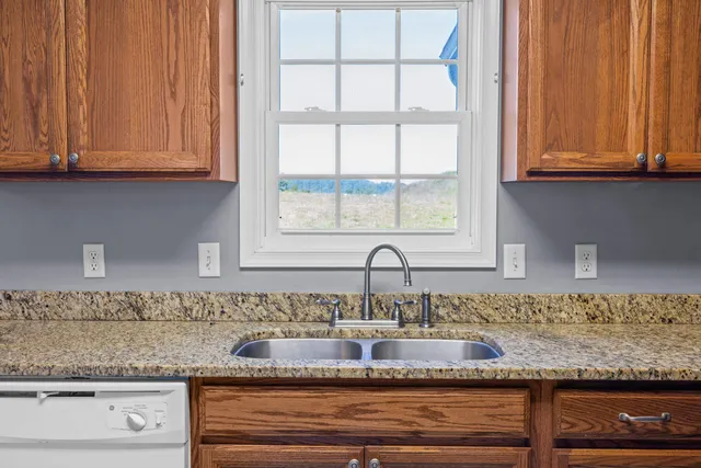 a view with granite countertop a sink and cabinets