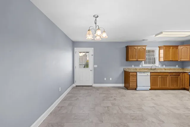 a view of an empty room with a kitchen