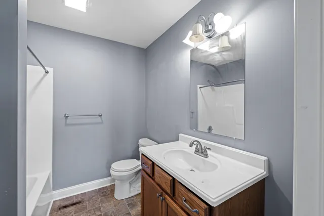 a bathroom with a sink a toilet and a mirror