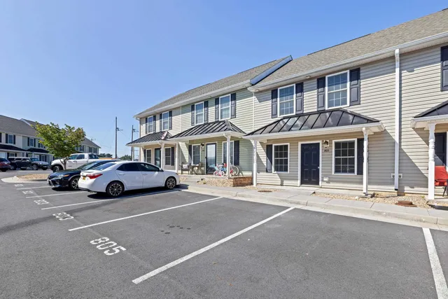 a front view of a residential apartment building with a yard