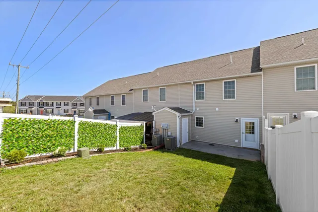 a view of a house with a patio and a yard