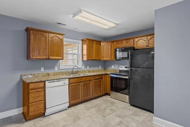 a kitchen with stainless steel appliances granite countertop a refrigerator and a stove top oven