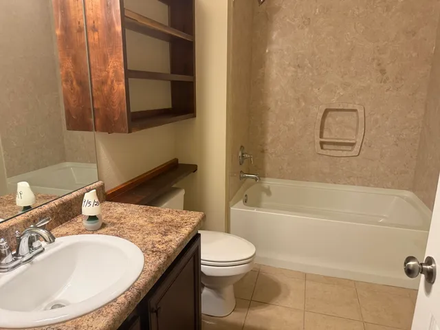 a bathroom with a granite countertop sink toilet and shower