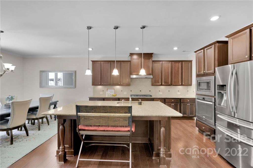 1397 Cilantro Court Tega Cay, SC 29708 - Photo 6 of 45 a kitchen with a refrigerator a stove a sink a dining table and chairs