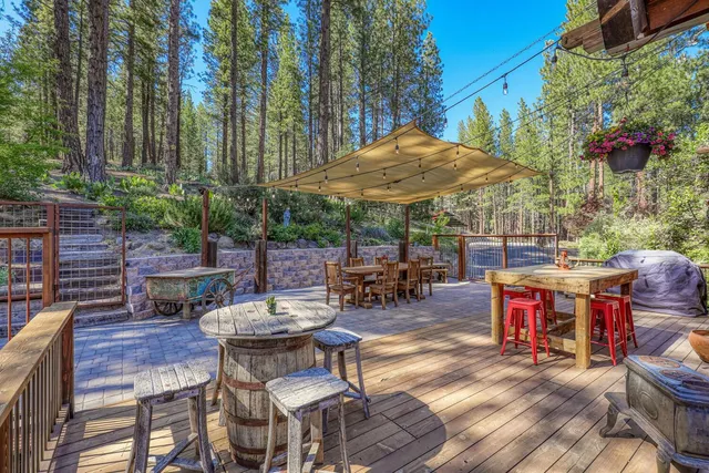 a view of a patio with table and chairs under an umbrella with a fire pit