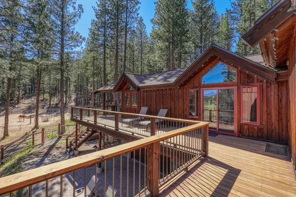 a view of house with wooden deck and furniture