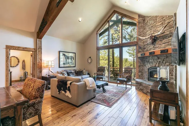 a living room with furniture large window and wooden floor