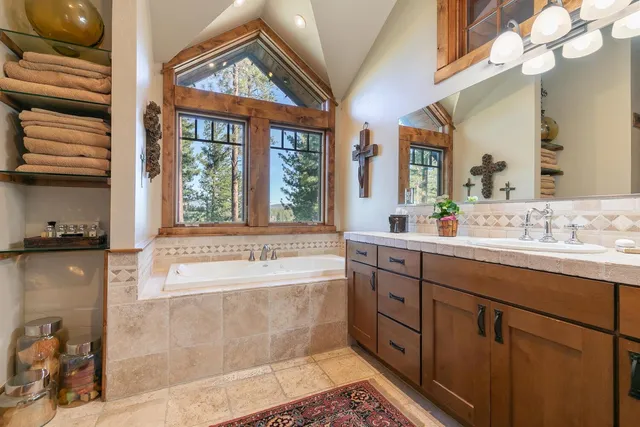 a spacious bathroom with a tub sink and mirror