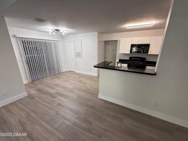 a view of a kitchen with stainless steel appliances wooden floor and wooden floor