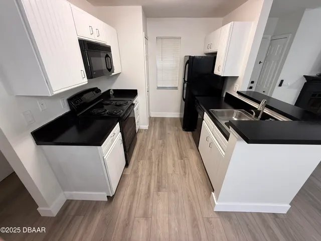a kitchen with a sink and wooden floor