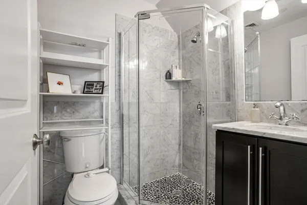 a bathroom with a granite countertop sink toilet and shower