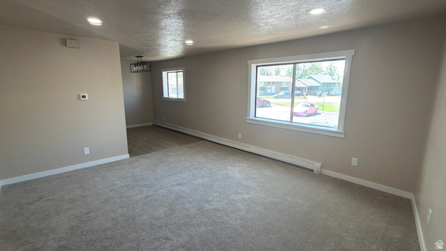 647 Swenson Avenue, Unit 4 Springville, UT 84663 - Photo 5 of 14 Unfurnished room with a baseboard heating unit, a textured ceiling, recessed lighting, and carpet floors