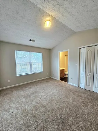 an empty room with windows and fireplace