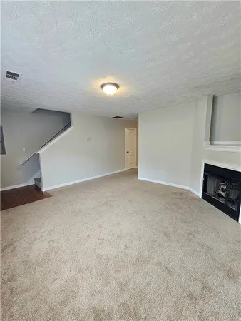 a view of an empty room with a fireplace and a window