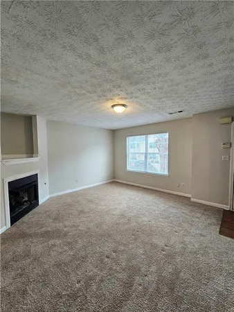 a view of empty room with a fireplace