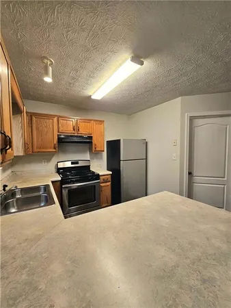 a kitchen with stainless steel appliances a stove a refrigerator and a sink