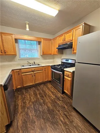 a kitchen with stainless steel appliances granite countertop a stove a sink dishwasher and a refrigerator