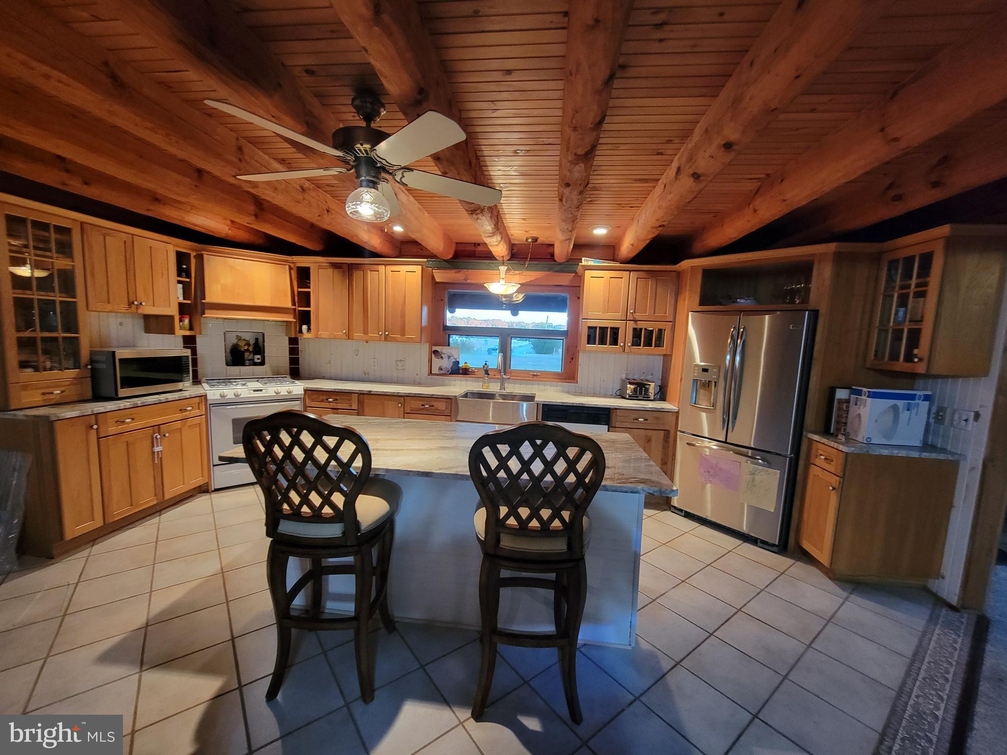 678 Walker School Road Townsend, DE 19734 - Photo 14 of 32 a kitchen with stainless steel appliances a table chairs and a refrigerator
