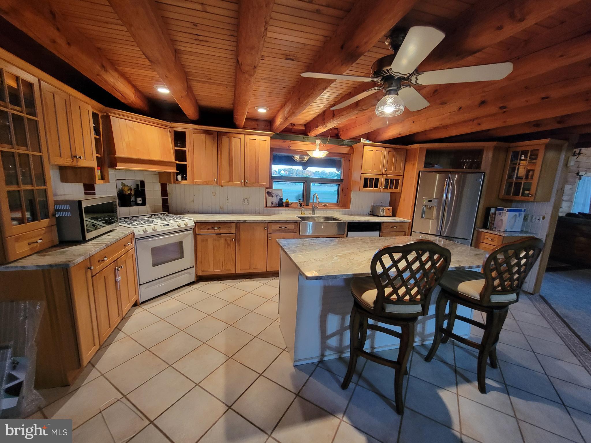 678 Walker School Road Townsend, DE 19734 - Photo 16 of 32 a open kitchen with stainless steel appliances granite countertop a sink a stove a dining table and chairs with wooden floor