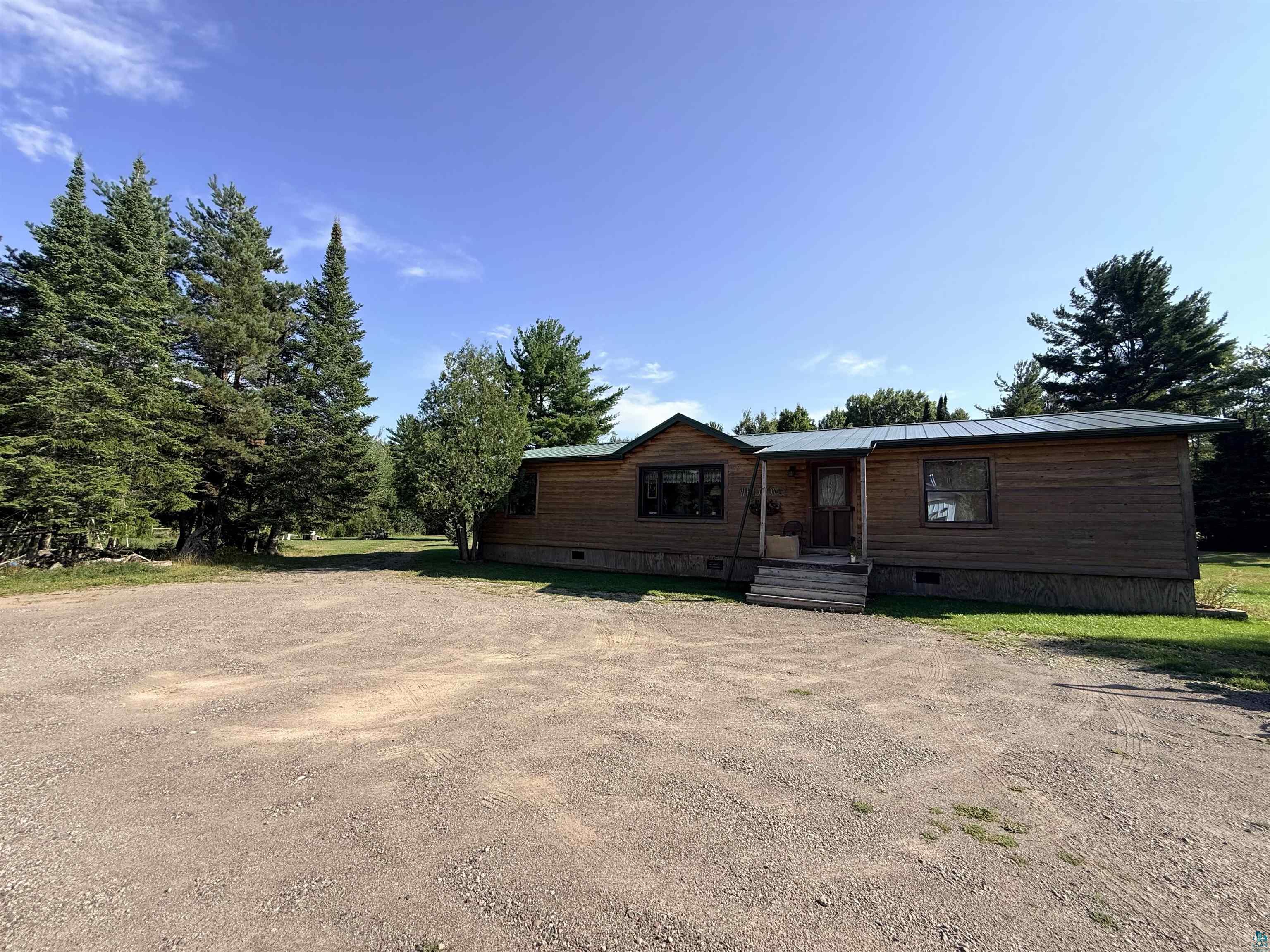 124 Nynas Road Esko, MN 55733 - Photo 2 of 14 Wood-sided exterior with a covered entry, multiple windows, and a metal roof