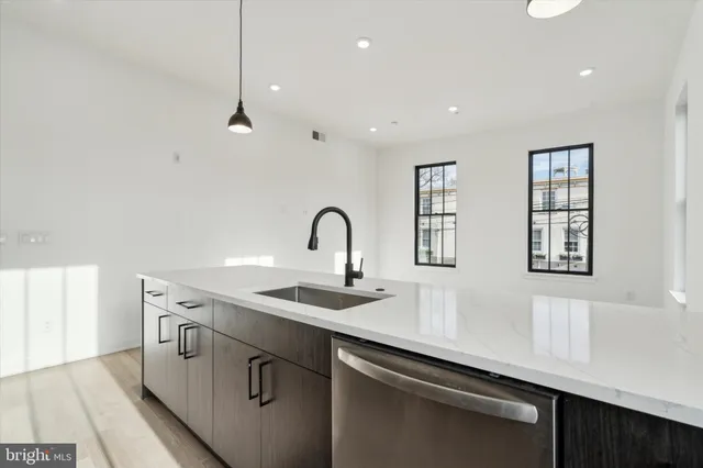 a kitchen with stainless steel appliances a sink a stove and a window
