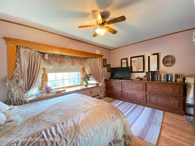 a view of a hallway with wooden floor and a bathroom