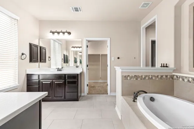 a bathroom with a toilet a sink a mirror and bathtub