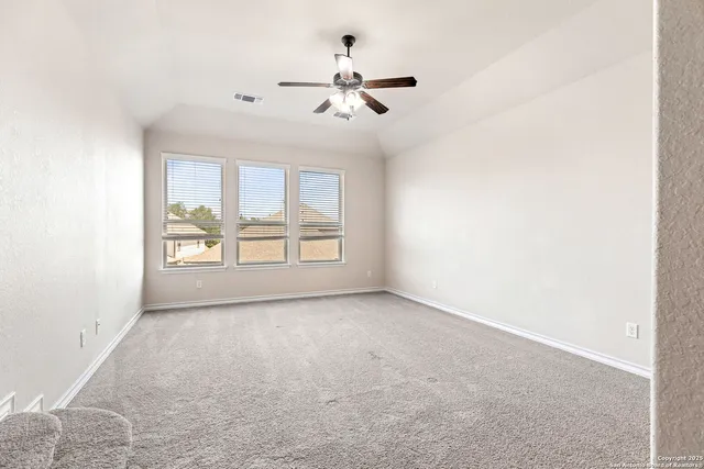 a view of an empty room with a ceiling fan