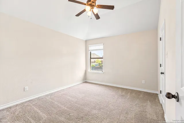 an empty room with a window and a fan