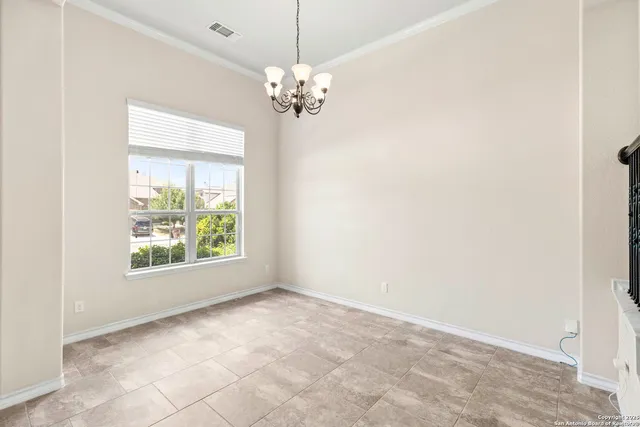 a view of an empty room with chandelier
