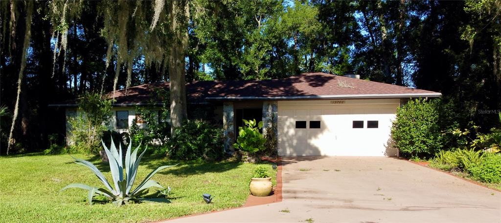 19786 Southwest 85th Loop Dunnellon, FL 34432 - Photo 1 of 91 a front view of a house with garden
