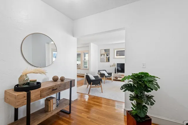 a living room with furniture potted plant and a mirror